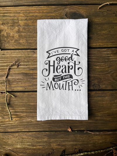 White 100% cotton kitchen dish towel with black vinyl design that says "i've got a good heart but this mouth...".  A great and funny kitchen gift!