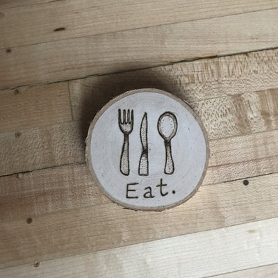 Wood Farmhouse Kitchen Magnet.  Has wood burned design of a fork, knife, and spoon and the word "Eat" under the utensils.  Unique housewarming gift.