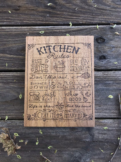 Wood Kitchen Rules Sign.  Rules include Rise and Grind, Be Grateful, Don't Flip Out, Simmer Down, Roll With It, Just Beat it, whip it good, life is short lick the bowl, and eat it or starve.  Has decorative border and correlating kitchen utensils with quotes.Wood Burned by hand making this handmade sign a unique kitchen gift.