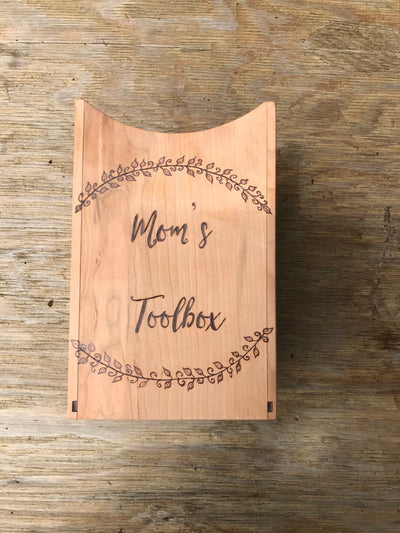 Handmade Wooden Utensil Holder.  Has wood burned designs of vines/leaves on the top and bottom with the words "mom's toolbox" in the middle.  Can be personalized.  Holds several utensils.
