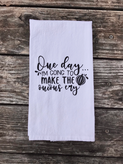A white cotton kitchen towel with black vinyl design of "one day I'm going to make the onions cry" quote.  A cute kitchen gift.